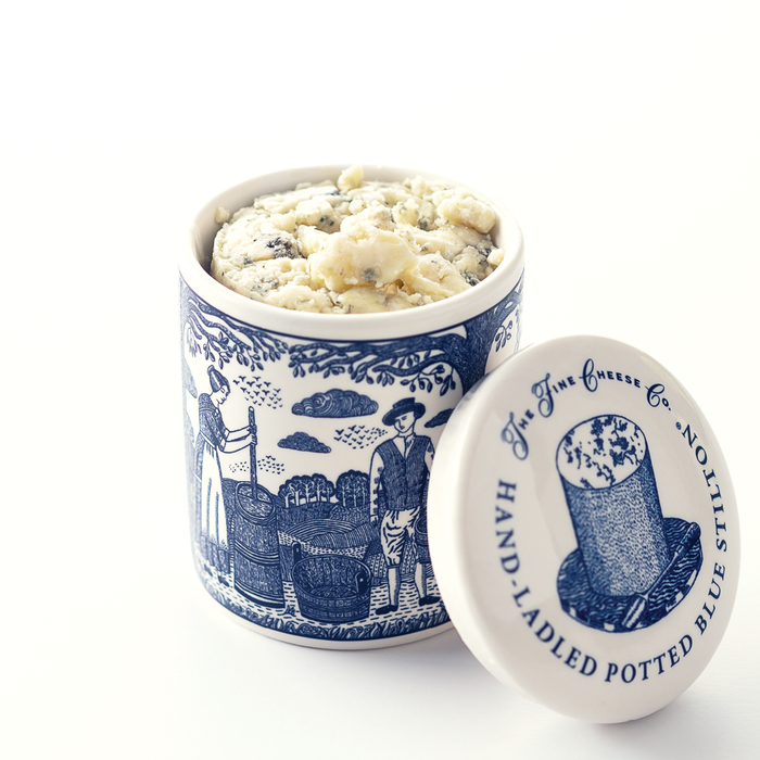 A blue and white ceramic jar filled with hand ladled stilton cheese.