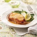 one miso sea bass filet on a plate with lemon and green beans.
