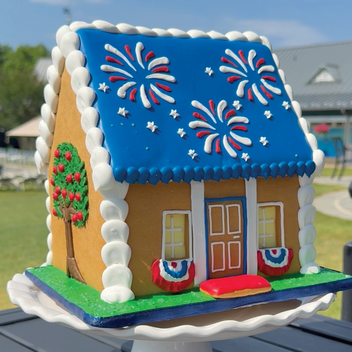 Fourth of July themed gingerbread house with apple tree on left side